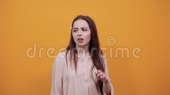 年轻失望的女人用手指合上耳朵挤着脸视频的预览图