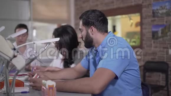 疲惫的中东牙科学生用手抱头特写穿蓝色制服的年轻人的侧视视频的预览图