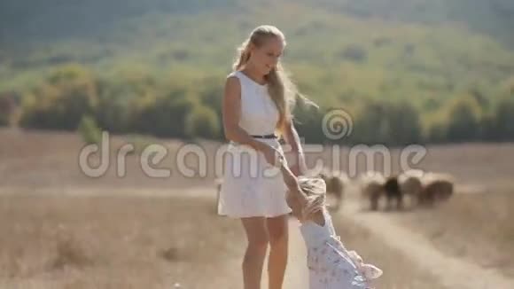 漂亮的妈妈穿着轻便的衣服抱着她的小女儿视频的预览图