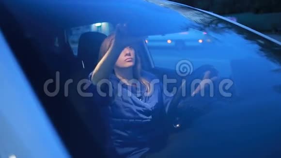 女孩坐在汽车的车轮前嘴唇上涂着唇彩视频的预览图