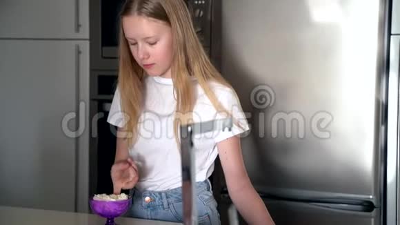 少女在厨房吃奶油甜点视频的预览图
