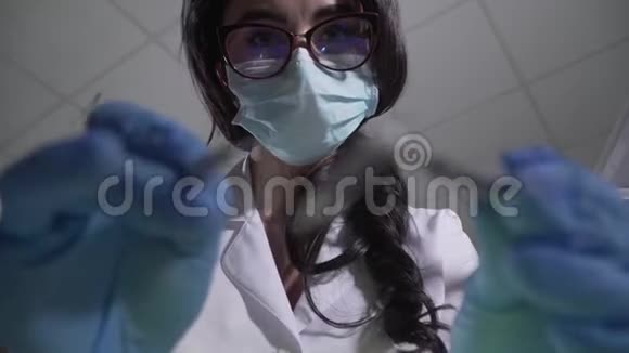 戴着眼镜和防护面罩的美丽的深黑肤色白种人女性使用牙科设备视频的预览图
