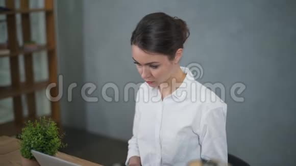 女孩在办公室用笔记本电脑工作视频的预览图