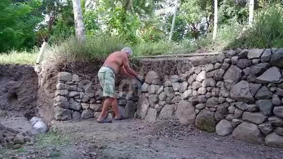 人做砖石在热带村庄的某个地方视频的预览图