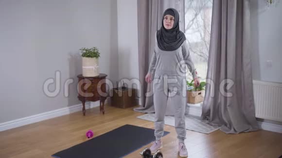 年轻强壮的穆斯林妇女早上在家锻炼穿着头巾在室内运动的漂亮女人视频的预览图