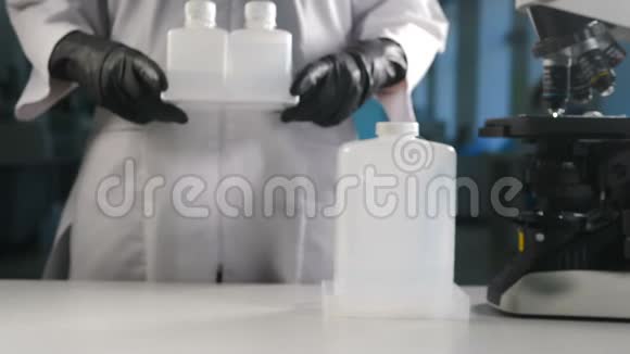现代实验室理念戴黑手套的科学家把装有显微镜的白色塑料瓶视频的预览图
