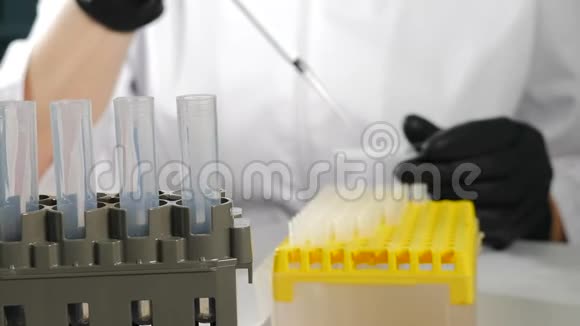 现代微生物机柜中戴黑色手套的实验室工作人员女科学家身穿医用制服的正面视角视频的预览图