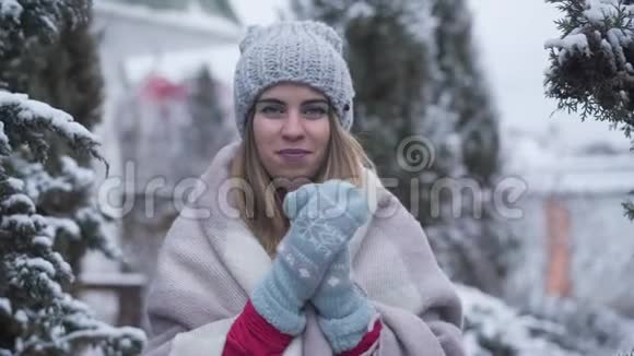 戴着冬帽和手套站在户外的快乐年轻白种人女人的肖像微笑迷人的女士摆姿势视频的预览图