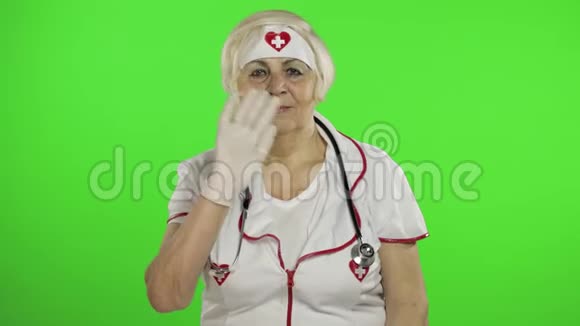 戴防护面罩的老年白种人女医生挥舞着双手视频的预览图