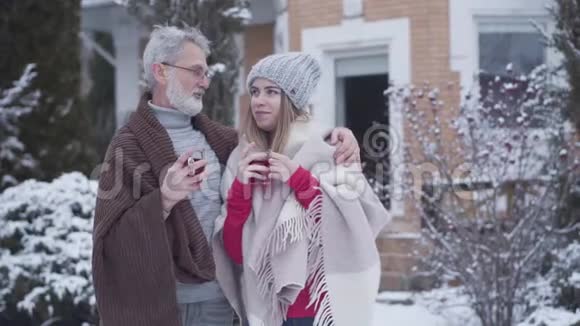 自信的高级男人在冬天和年轻女人说话拥抱伴侣英俊的高加索退休者享受时光视频的预览图