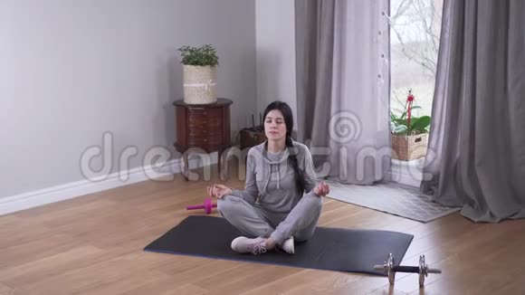 俯视长长的白种人女人在室内冥想美丽的年轻女子在家练习瑜伽视频的预览图