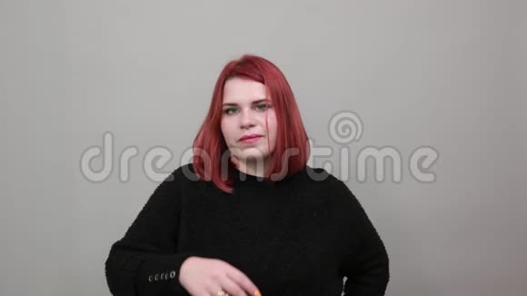 红头发的胖女人穿着黑色毛衣诱惑女人摸食指唇视频的预览图