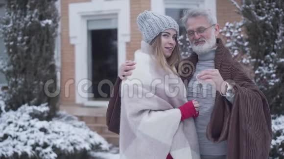 快乐的高加索人拥抱年轻的妻子在镜头前吹嘘新房子的钥匙头发灰白的微笑视频的预览图