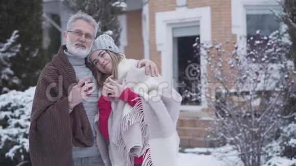 可爱的白人夫妇的肖像年龄差异在冬天摆姿势年轻貌美的老人视频的预览图