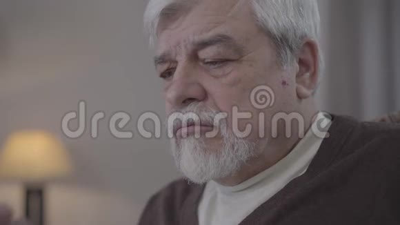 莫普眼中的高级男子在智能手机屏幕上滑动的特写肖像老白种人退休人员在室内使用电话现代视频的预览图