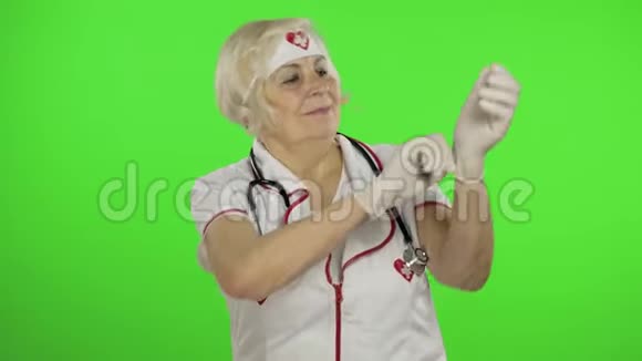 老年白种人女医生戴防护手套大流行病冠状病毒视频的预览图