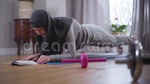 强壮的穆斯林妇女穿着头巾和运动服做运动做运动锻炼和读书自信的年轻女子视频的预览图