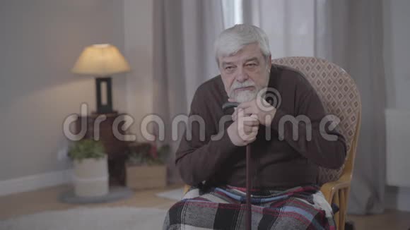 悲伤的白种人老人叹息和眺望的肖像让退休的男性在家里度过一个孤独的夜晚社会视频的预览图