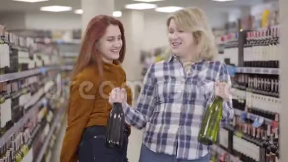 快乐的白种人女人在酒铺里跳舞手里拿着一瓶饮料开朗的金发碧眼的女性视频的预览图