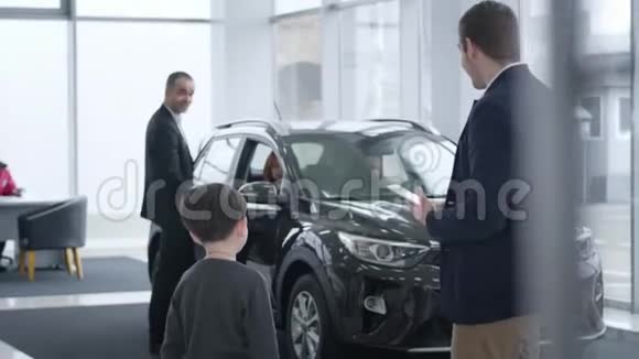 黑发白人小男孩与汽车经销商交谈的后视图视频的预览图