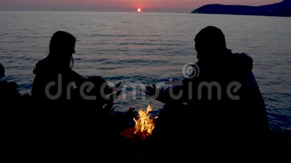 年轻的白种人一家人坐在篝火旁享受着亲密的关系视频的预览图