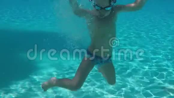 小男孩在水池里的水里潜水挥舞着双手视频的预览图