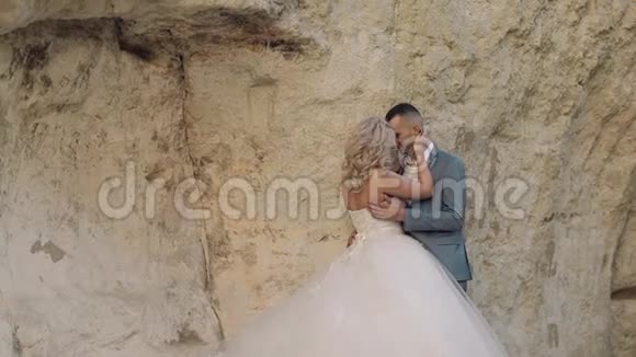 结婚夫妇站在山腰上新婚夫妇新郎和新娘视频的预览图