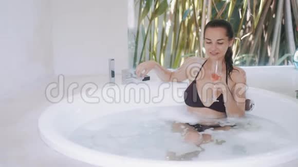 漂亮的女人喝香槟在别墅房间洗澡视频的预览图