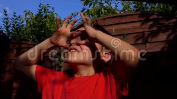 小男孩用手指用望远镜做手势看着天空视频的预览图
