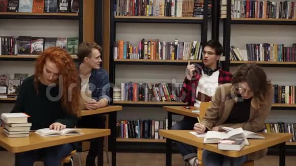 聪明的男女学生学习在大学图书馆准备考试坐在分开的桌子旁视频的预览图