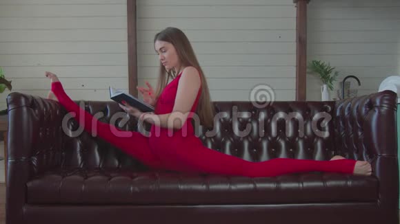 柔软的女孩坐在沙发上的细绳看书视频的预览图