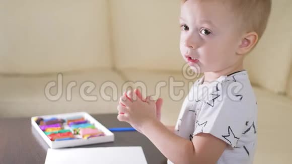 孩子在家玩塑料有创意的孩子在桌子上玩粘土成型视频的预览图