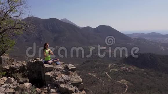 年轻的运动女子在山顶上沉思视频的预览图