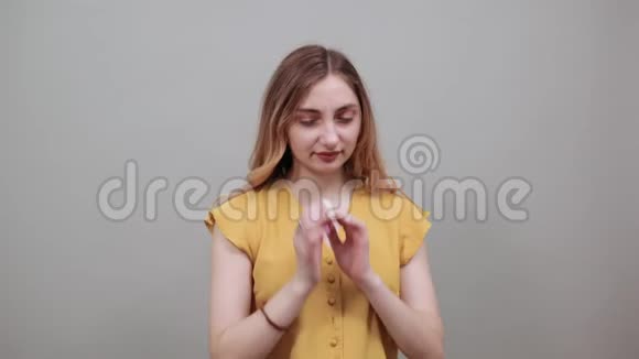 年轻的金发女人用手指闭上耳朵向下看视频的预览图