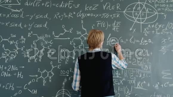 青年数学教师课堂黑板书写方程式的后视图视频的预览图