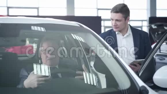 自信的年轻白种人汽车经销商咨询老客户坐在车里成功成熟视频的预览图