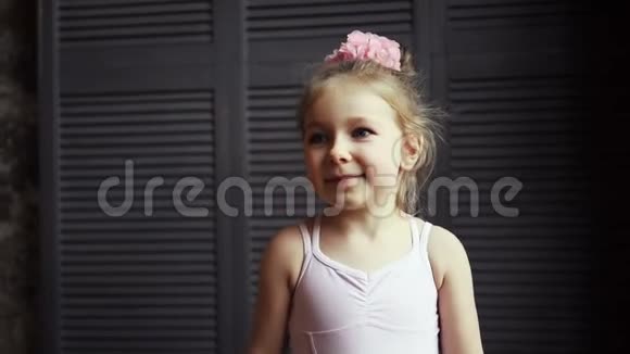 一个可爱的女婴对着镜头微笑的肖像小金发孩子笑了慢动作视频的预览图