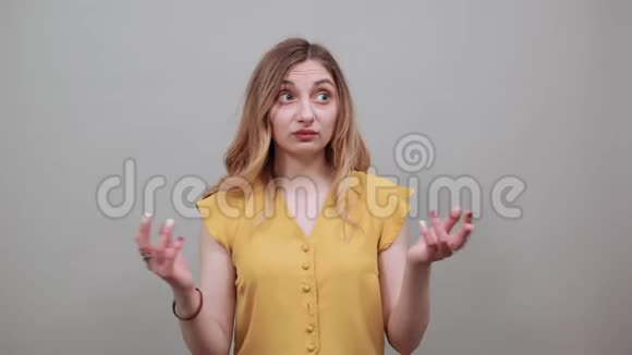 失望的女人伸出手看着戴着黄色衬衫的相机视频的预览图