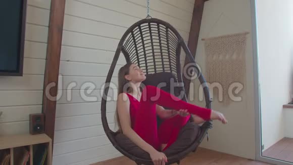 运动的女人坐在秋千椅上摆姿势视频的预览图
