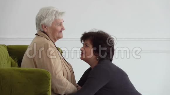 美丽的中年妇女正在说话拥抱她年迈的母亲视频的预览图