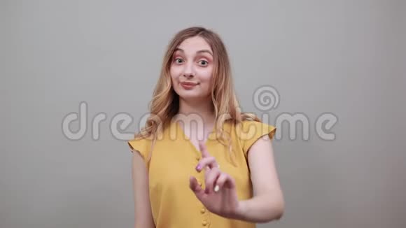 白种人女人在靠近耳朵的地方做电话手势手指指向摄像机视频的预览图