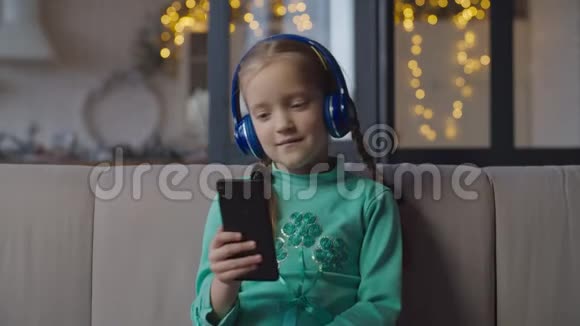 戴着耳机听手机音乐的女孩视频的预览图