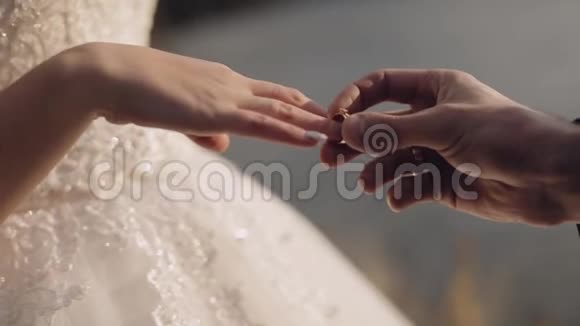 新郎戴上新娘的手指订婚戒指新婚夫妇视频的预览图
