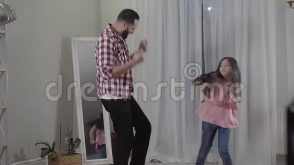 正面中东父女在家跳舞年轻快乐的女孩在室内玩得很开心视频的预览图