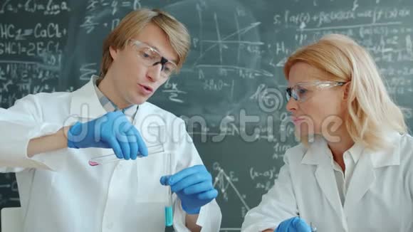 在实验室工作的女性和男性化学家他们的试管忙于实验视频的预览图