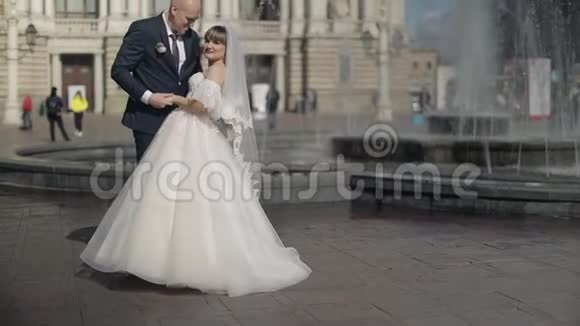 老镇中心的新婚夫妇接吻新郎新娘婚礼视频的预览图