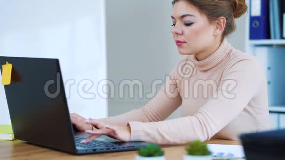 积极的女孩在办公室的笔记本电脑上打字视频的预览图