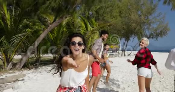 年轻女孩欢迎你和快乐的人一起在海滩上奔跑让男女游客在海上度假视频的预览图