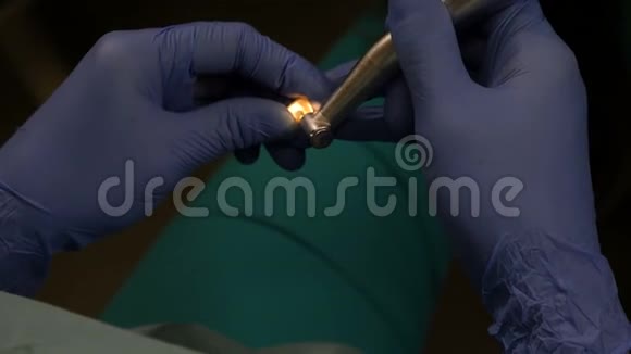 化妆品牙科贴面暗影牙科医生手拿着白色贴面和钻孔的特写镜头医药视频的预览图