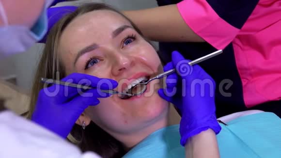牙医正在检查一位女性病人的牙齿视频的预览图